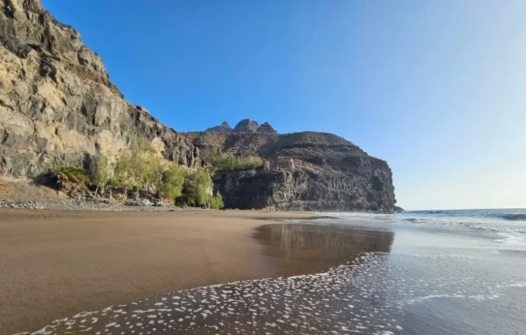 A GüiGüi strand fekete homokos partja és sziklás partvidéke Gran Canarián